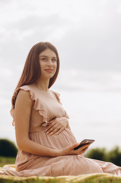Кавказская беременная женщина разговаривает по смартфону