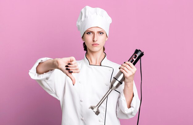 Caucasian pretty blonde woman chef concept with a hand mixer