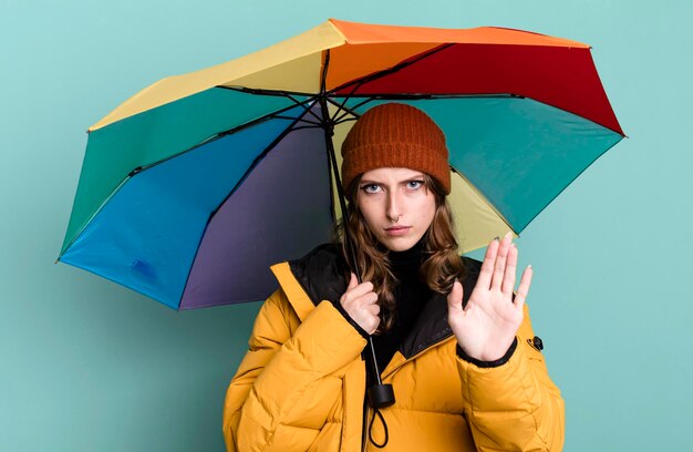 Photo caucasian pretty blonde woman with an umbrella winter and cold concept