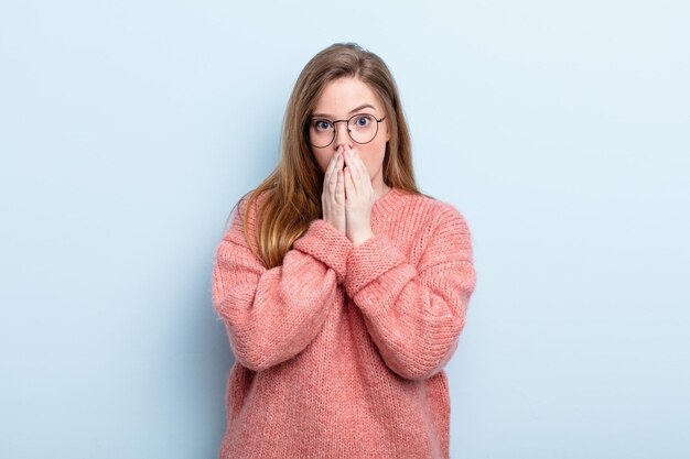 caucasian red hair woman feeling worried, upset and scared, covering mouth with hands, looking anxious and having messed up