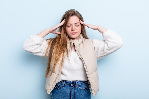 caucasian red hair woman looking concentrated, thoughtful and inspired, brainstorming and imagining with hands on forehead