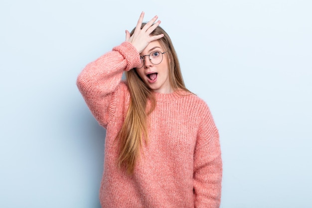 Caucasian red hair woman raising palm to forehead thinking oops, after making a stupid mistake or remembering, feeling dumb