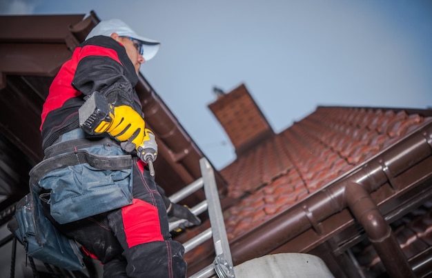 Caucasian Roof Worker with Power Tool Residential Construction Site