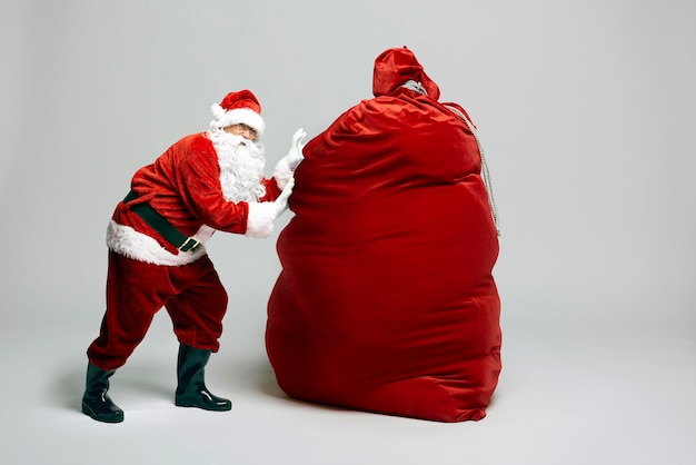 クリスマスプレゼントの巨大な袋を持った白人のサンタクロース