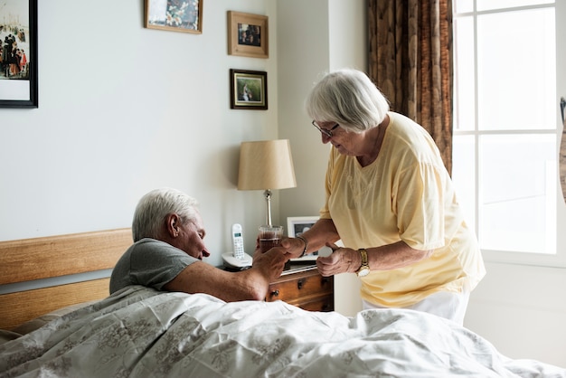 Photo caucasian senior man taking pills in his bed