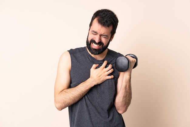 Uomo caucasico di sport con la barba che fa sollevamento pesi isolato