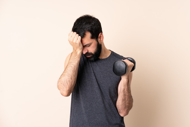Caucasian sport man with beard making weightlifting with headache
