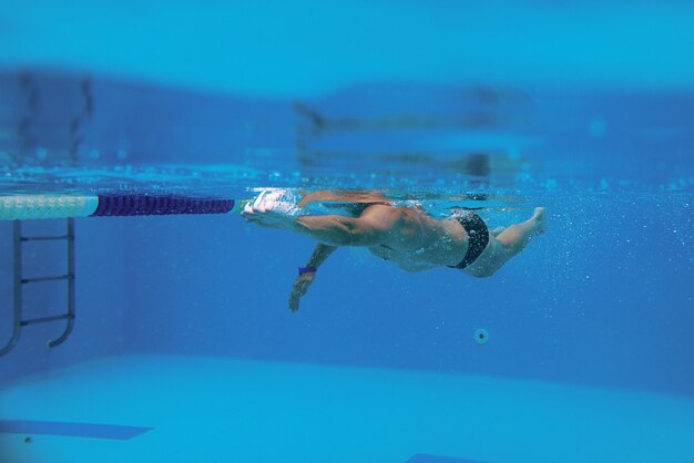 水中プールで泳ぐための肩甲骨で泳ぐ白人スポーツマン