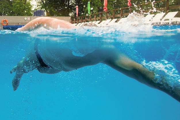 Caucasian sportsman swimming with shoulder blades underwater