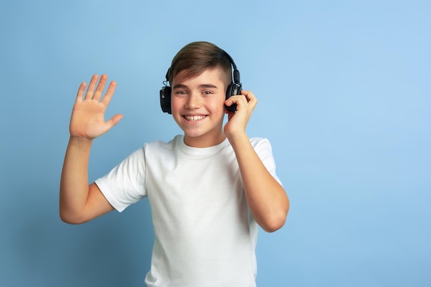 Caucasian teen's portrait isolated on blue studio background