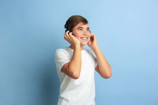 Caucasian teen's portrait isolated on blue studio background