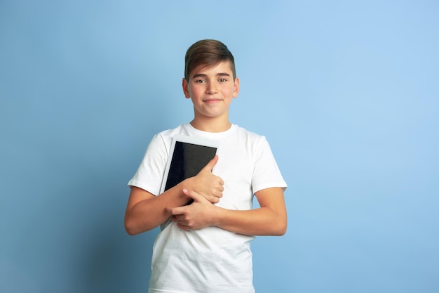 Caucasian teen's portrait isolated on blue