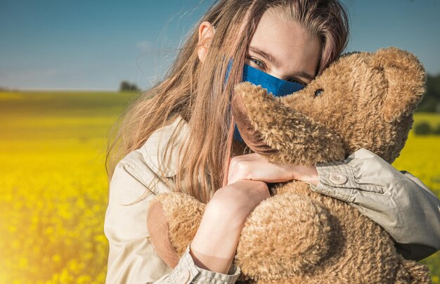 Caucasian teenage girl hugging her teddy bear during pandemic
