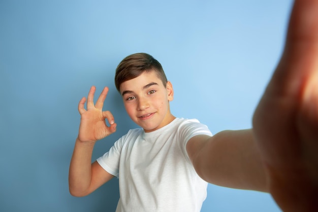 Caucasian teens portrait isolated on blue studio background