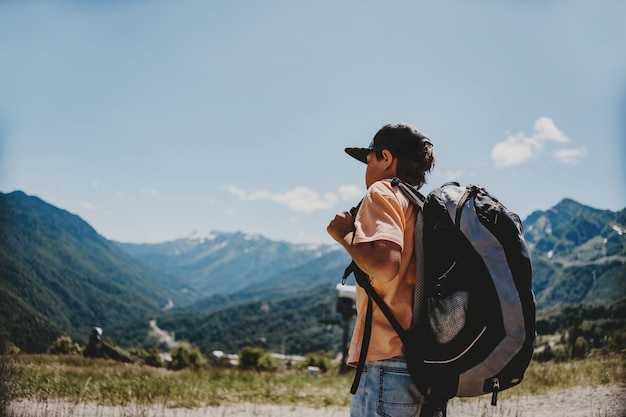 caucasian tourist boy with backpack in mountains High quality photo