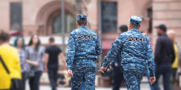 Foto caucasico due poliziotti che camminano in città