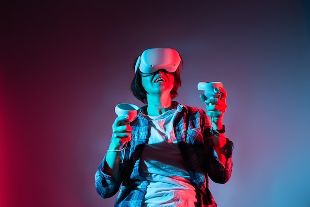 가상 현실 헬멧을 쓴 백인 여성 35-40년. VR 안경, 네온 불빛의 기술 개념.