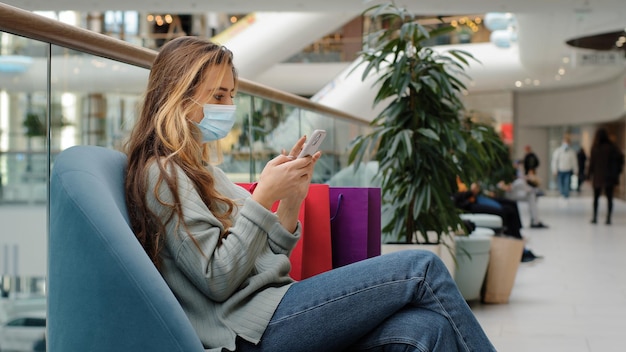 Foto l'acquirente di una donna caucasica che indossa una maschera medica si è rilassato con le borse della spesa