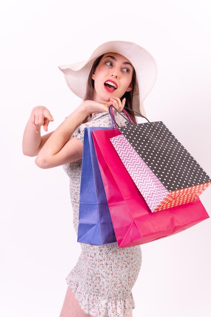 Caucasian woman holding shopping bags on white background with copyspace sales concept