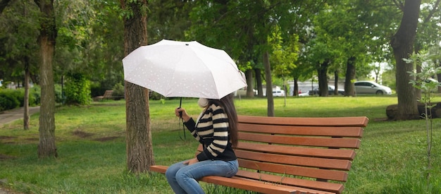 Caucasian woman holding umbrella in park