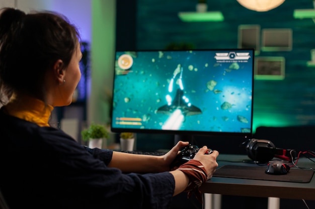 무선 조이스틱을 들고 가상 비디오 게임을 하는 백인 여성. 게임 홈 스튜디오에서 전문 장비를 사용하여 가상 스트리밍 사이버 공연 라이브 토너먼트