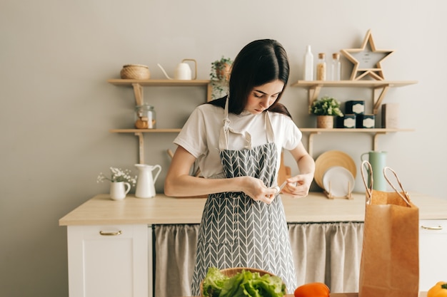 Caucasian woman is tying an apron preparation to cooking food