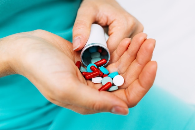 Caucasian woman is typing medications and medicines in hand.