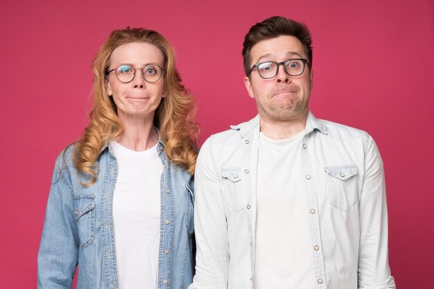 Caucasian woman and man in glasses pursing lips saving secret