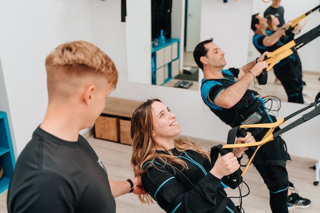 Caucasian woman and a middle-aged man doing push-ups on a rope