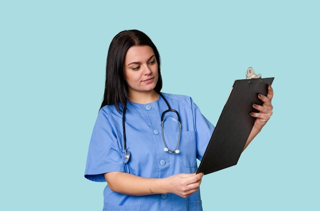 A Caucasian woman a nurse holds a stethoscope on an isolated background She represents care