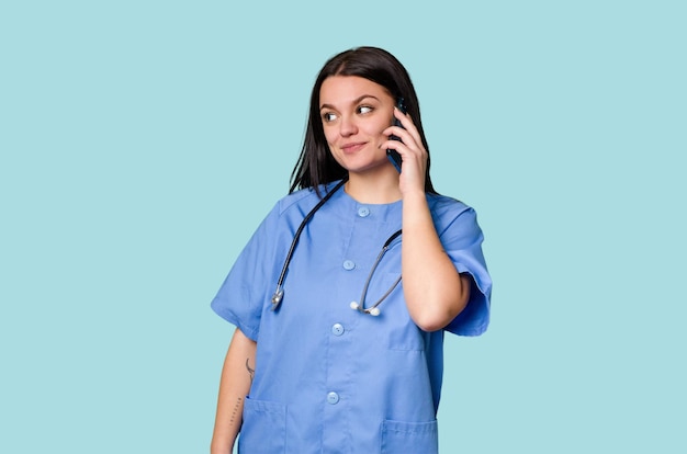 A Caucasian woman a nurse holds a stethoscope on an isolated background