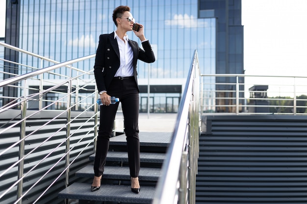 Caucasian woman in office clothes near the office building