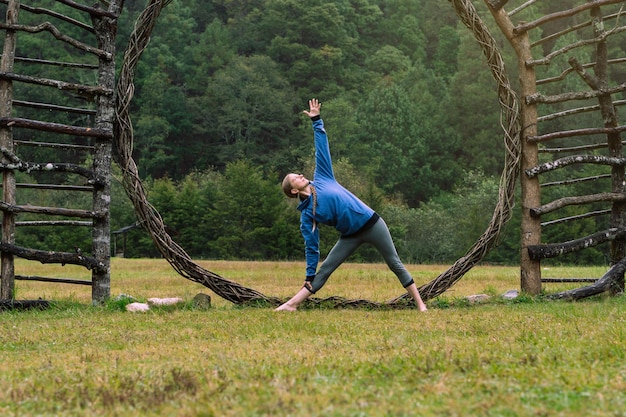 Caucasian woman practicing yoga in a forest. healthy\
lifestyle.