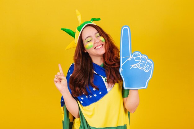 Caucasian woman redhead soccer fan from brazil using foam
finger cheering coleographed dance