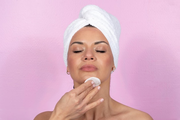 Photo caucasian woman removing make up daily routine with towel and cotton pad