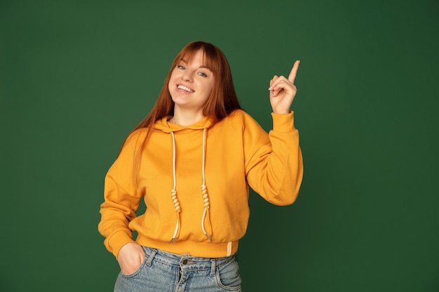 Caucasian woman's portrait isolated on green studio background with copyspace