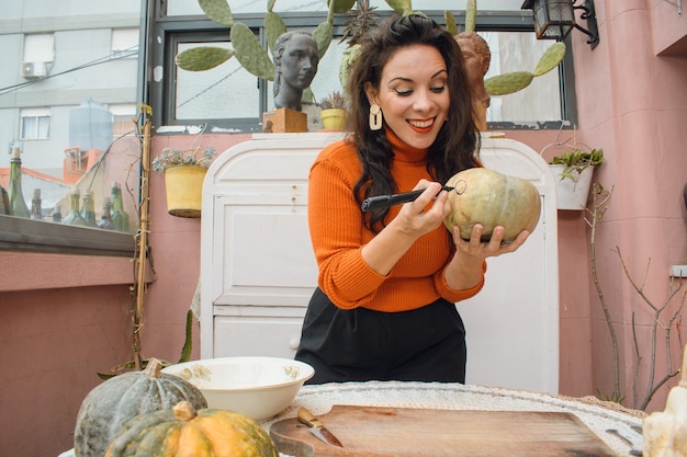 caucasian woman showing how to draw the eyes of a halloween pumpkin