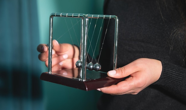 Caucasian woman showing Newtons cradle balls