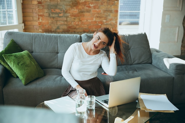 Caucasian woman singing during online concert at home isolated and quarantined. using camera, laptop, streaming, recording courses, dancing. concept of art, support, music, hobby, education.