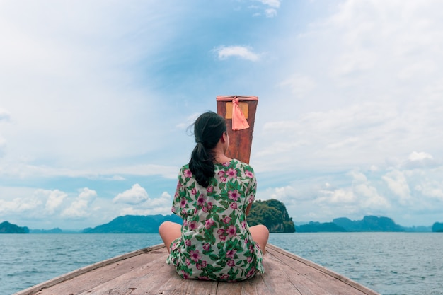 Caucasian Woman sit on boat out in the ocean rear view.