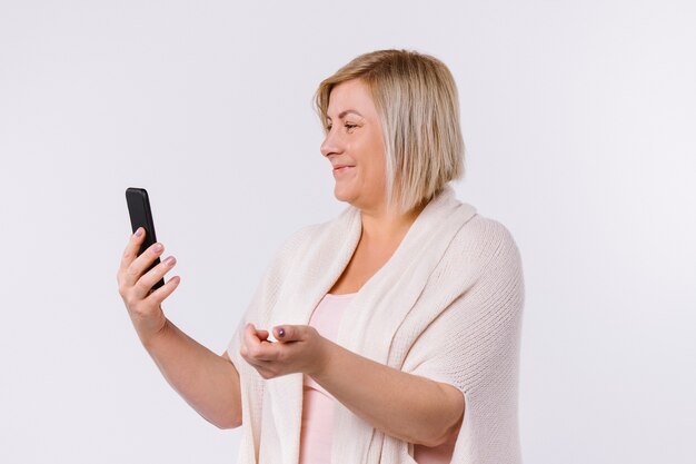 Caucasian woman smiles and communicates via video communication. White background. Profile photo. High quality photo