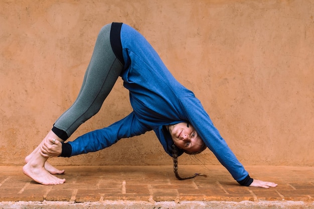 Caucasian woman in stretching position, practicing yoga and healthy lifestyle.
