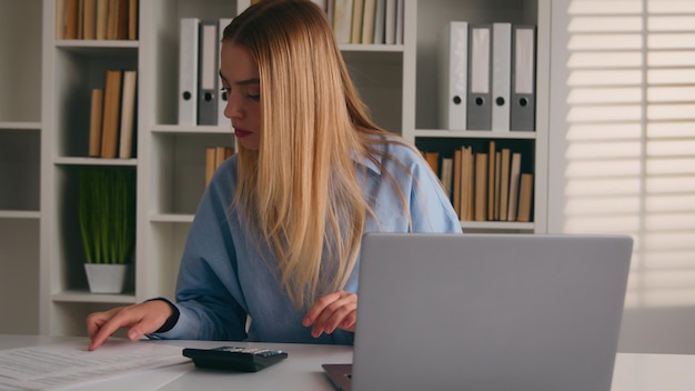 Caucasian woman using calculator laptop app calculate costs business incomes project expenses