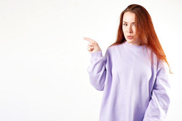 Caucasian woman in violet sweatshirt Natural look Smiling long red hair White background