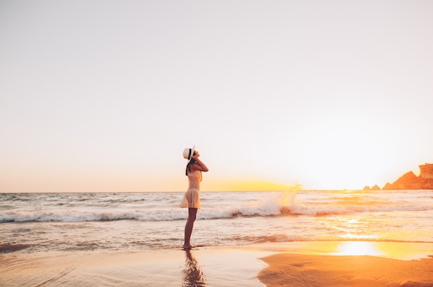 La donna caucasica cammina lungo la bella spiaggia