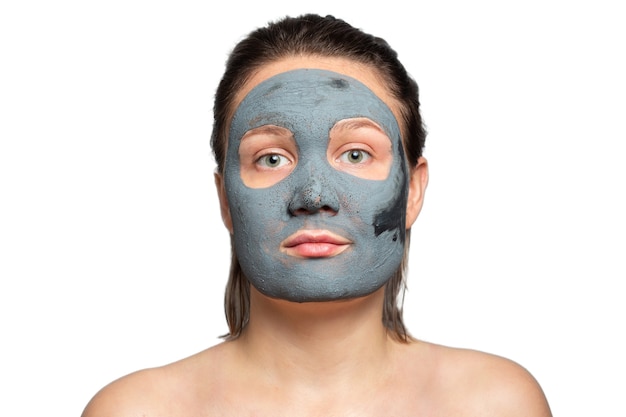 Photo caucasian woman with a clay or a mud mask on her face over white background.