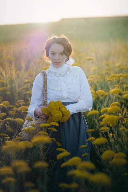 Caucasian woman with her hair up in the field full of yellow flowers under the sunlight