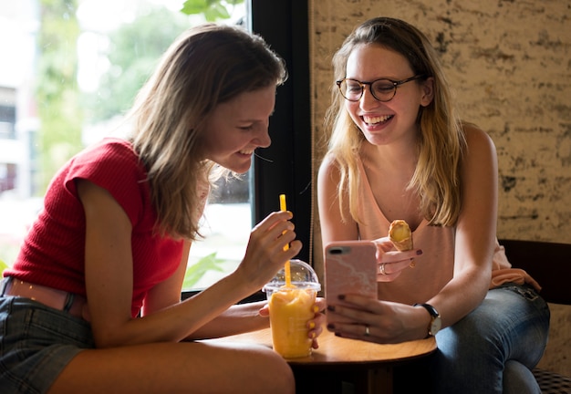 Donne caucasiche che godono il tempo nel caffè