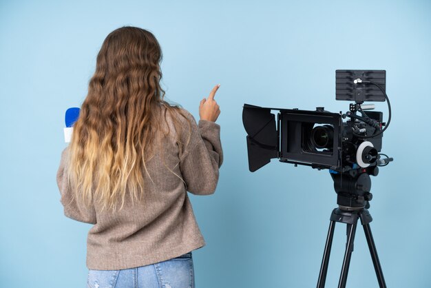 Photo caucasian young beautiful reporter woman over blue wall