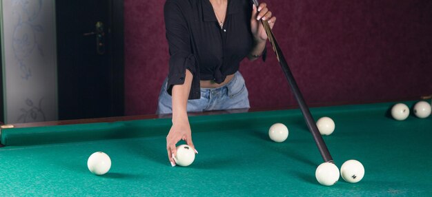 Caucasian young girl playing billiards